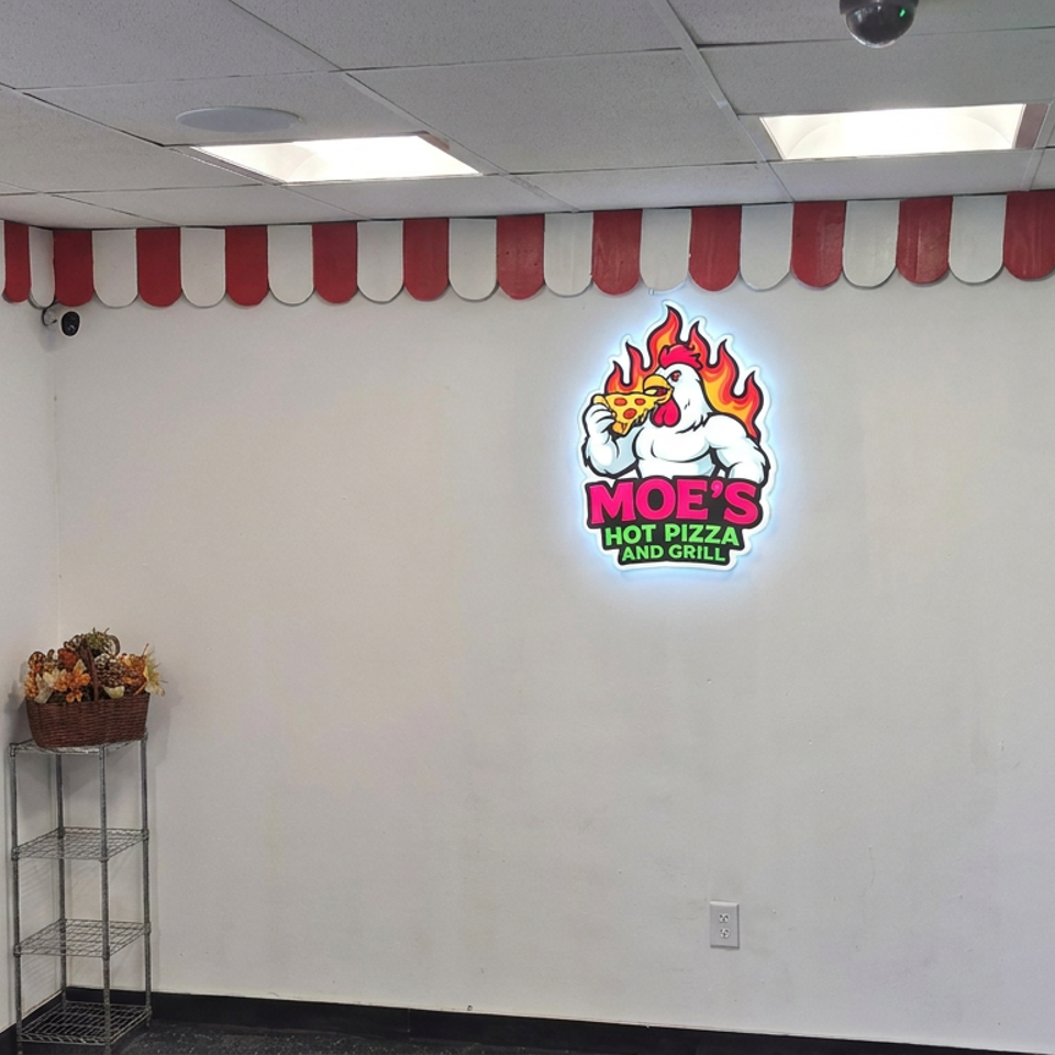 Moe’s Hot Pizza and Grill dining area featuring a glowing logo, red-and-white scalloped wall trim, and decorative ice cream display.