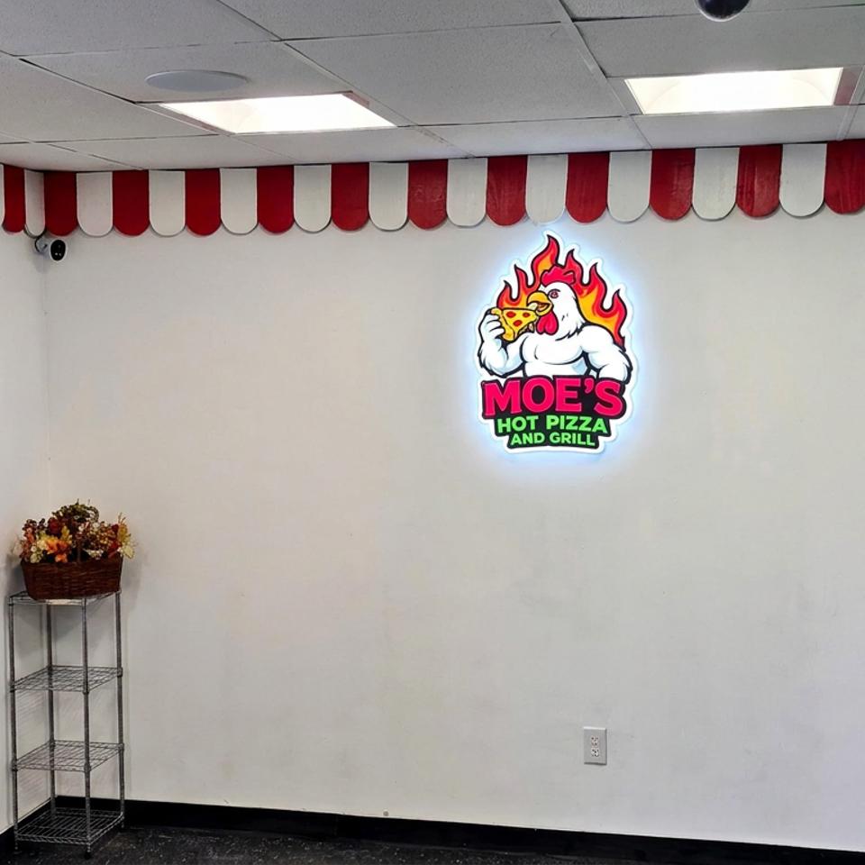 Moe’s Hot Pizza and Grill interior with illuminated logo, red-and-white striped valance, flower stand, and partially visible person.